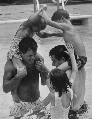 Robert Kennedy y Pierre Salinger jugando con sus hijos en una piscina (1964)